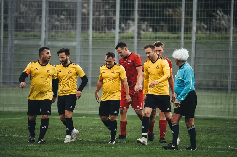 Amateur football team in yellow kits walking off the pitch