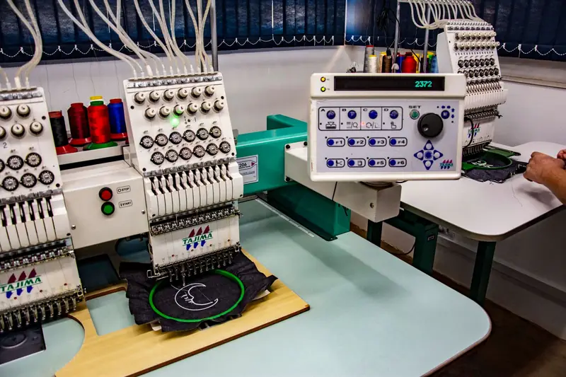 Multi-head embroidery machines stitching a logo onto a garment