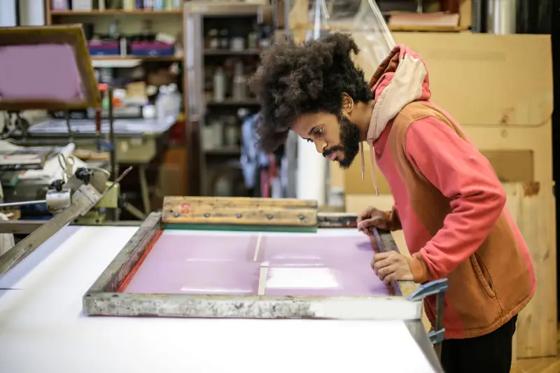 Printer lining up a screen on the print bench