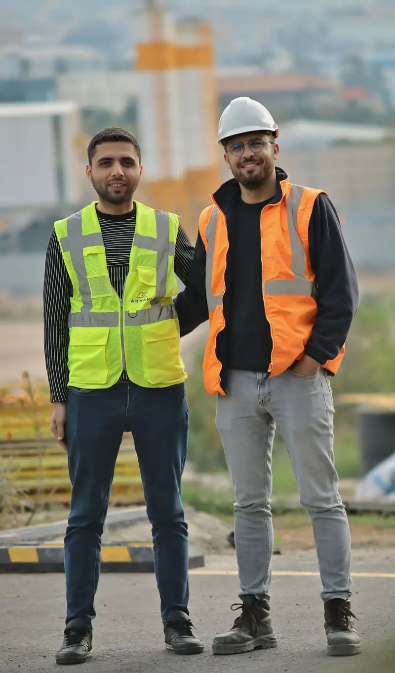 Two workers in hi-vis vests on a building site